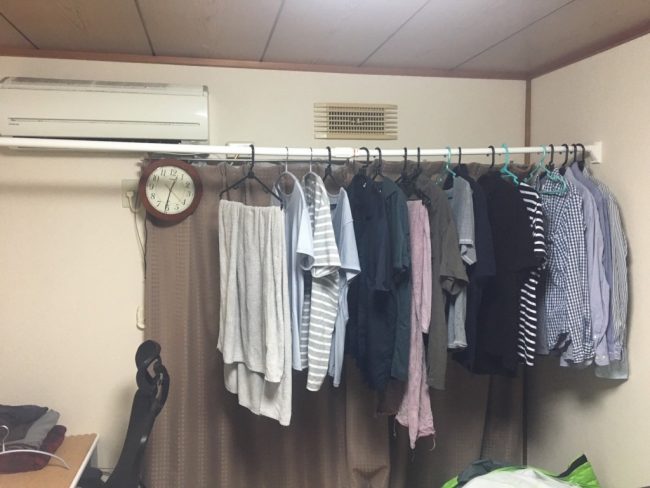 部屋に設置した突っ張り棒に服をかけた状態